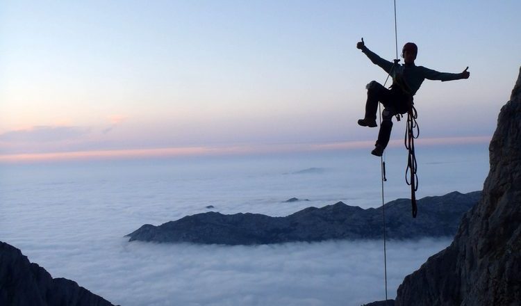 Rapelando ante un mar de nubes durante la escalada a "Sueños de invierno" en el Naranjo de Bulnes  (Col. Hnos. Cano)